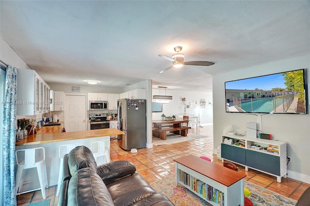 living room featuring ceiling fan and light tile patterned flooring