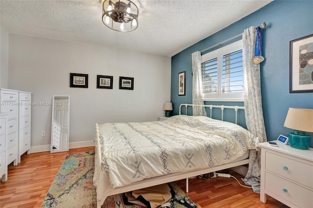 bedroom featuring light hardwood / wood-style flooring and a textured ceiling