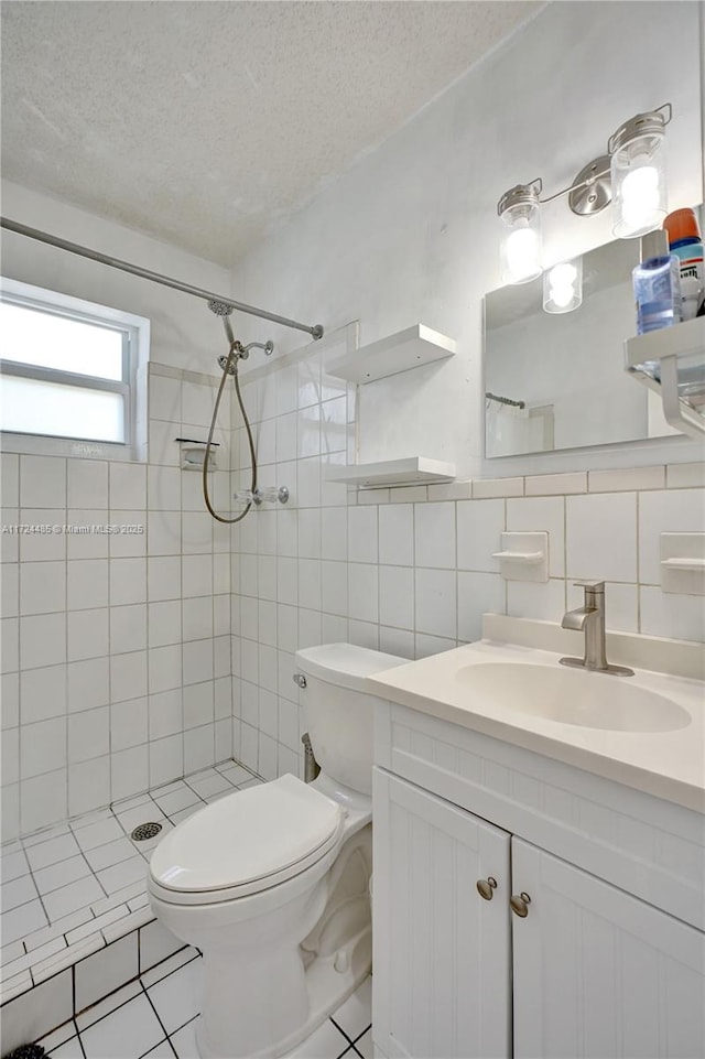 bathroom featuring decorative backsplash, vanity, a textured ceiling, tiled shower, and toilet