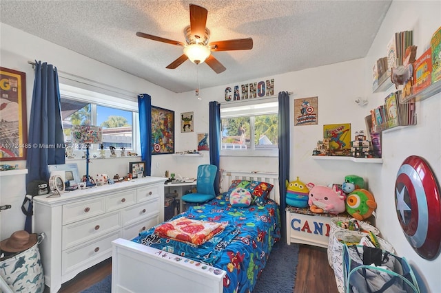 bedroom with ceiling fan, dark hardwood / wood-style flooring, and a textured ceiling