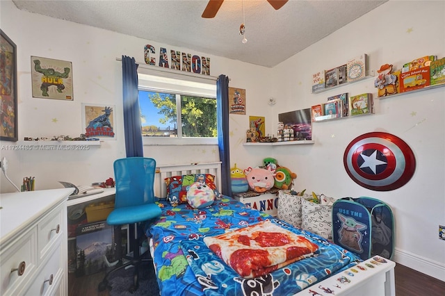 bedroom with ceiling fan, dark hardwood / wood-style floors, and a textured ceiling