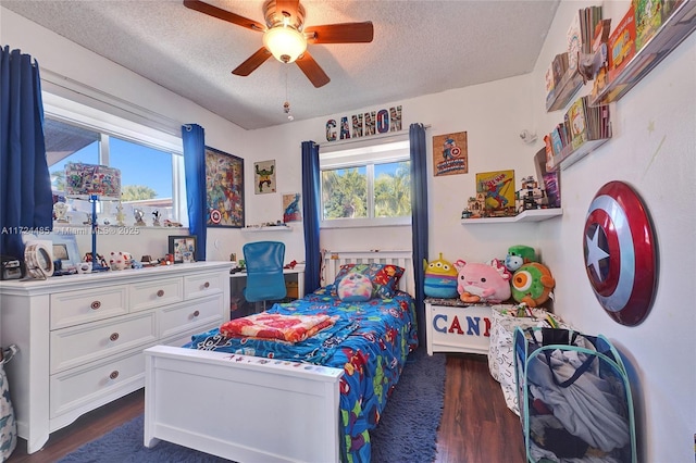 bedroom featuring multiple windows, ceiling fan, dark wood-type flooring, and a textured ceiling