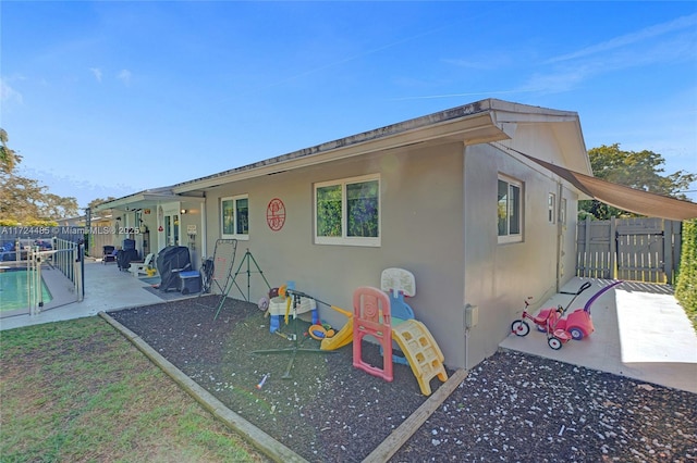 back of house with a fenced in pool and a patio