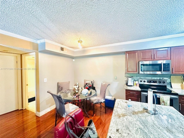 kitchen featuring light stone countertops, stainless steel appliances, dark hardwood / wood-style floors, crown molding, and a textured ceiling