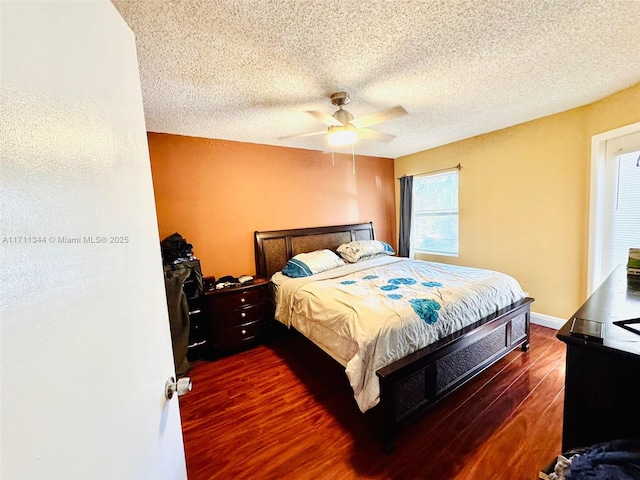 bedroom with a textured ceiling, dark hardwood / wood-style floors, and ceiling fan