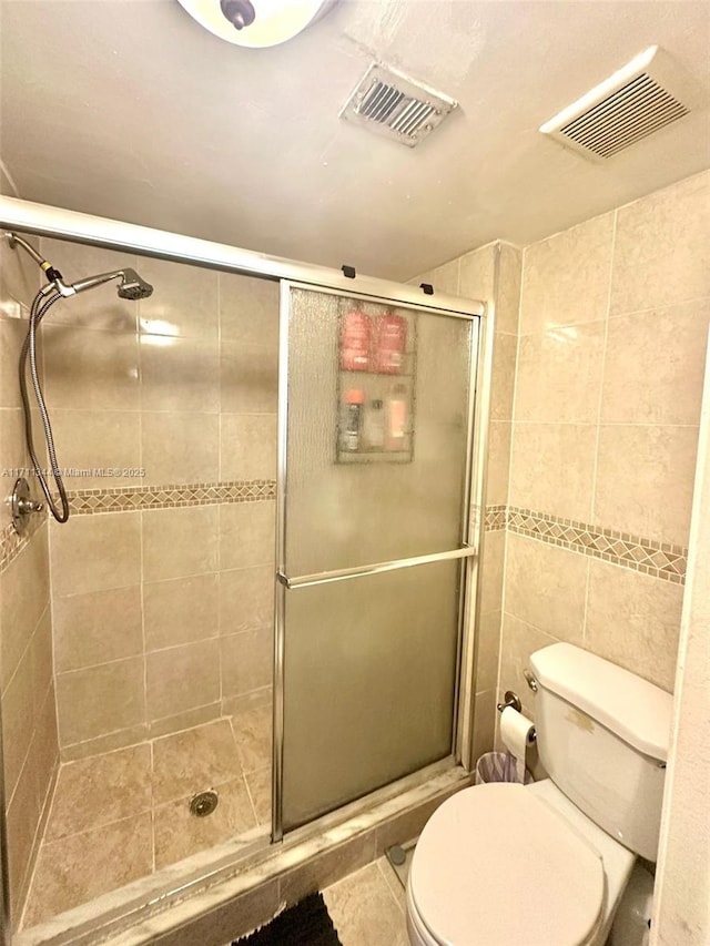 bathroom with toilet, walk in shower, and tile walls