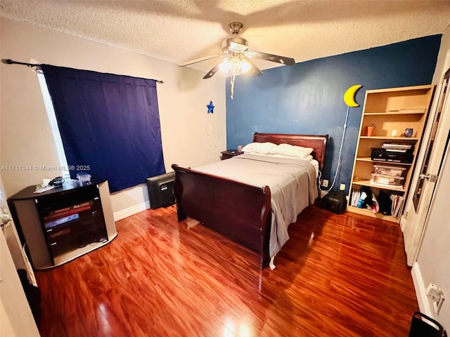 bedroom with ceiling fan, a textured ceiling, and hardwood / wood-style flooring