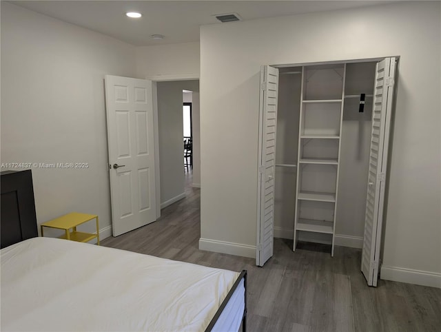 bedroom with hardwood / wood-style floors and a closet