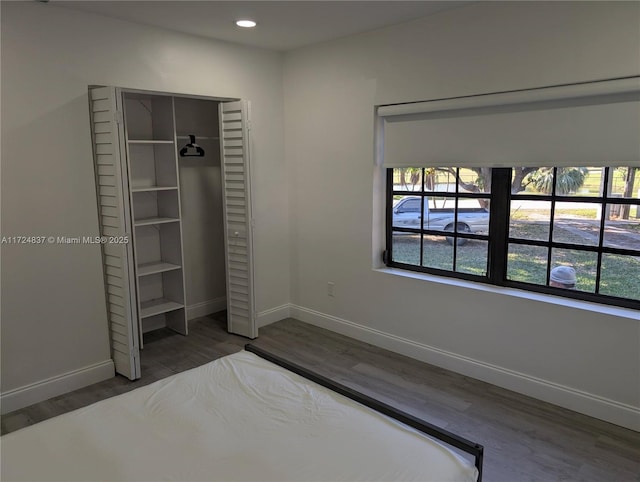 unfurnished bedroom featuring a closet and dark wood-type flooring