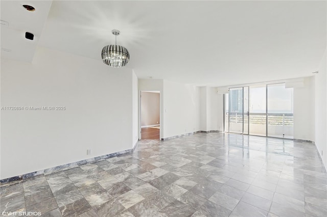 empty room with a chandelier and a wall of windows