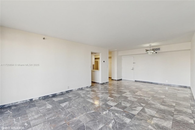 spare room with a notable chandelier