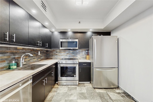 kitchen featuring appliances with stainless steel finishes, sink, and decorative backsplash