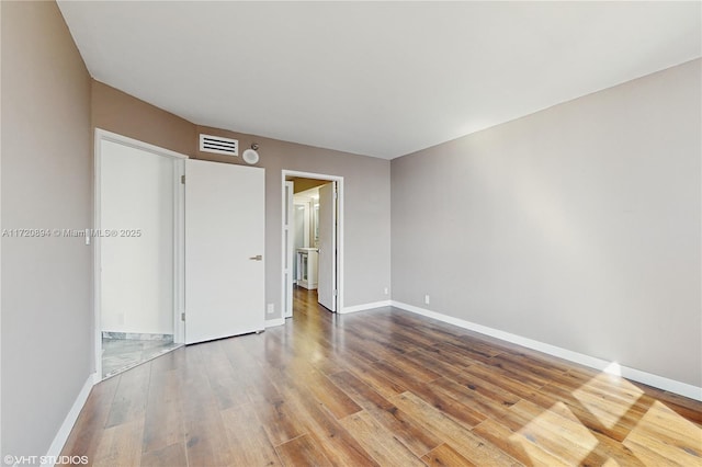 empty room with hardwood / wood-style flooring