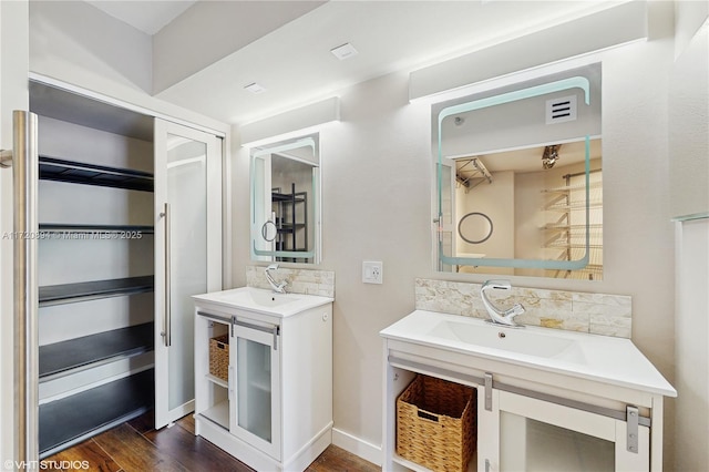 bathroom with wood-type flooring, decorative backsplash, and vanity