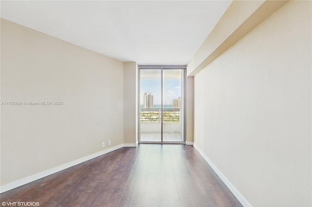 spare room featuring expansive windows and wood-type flooring