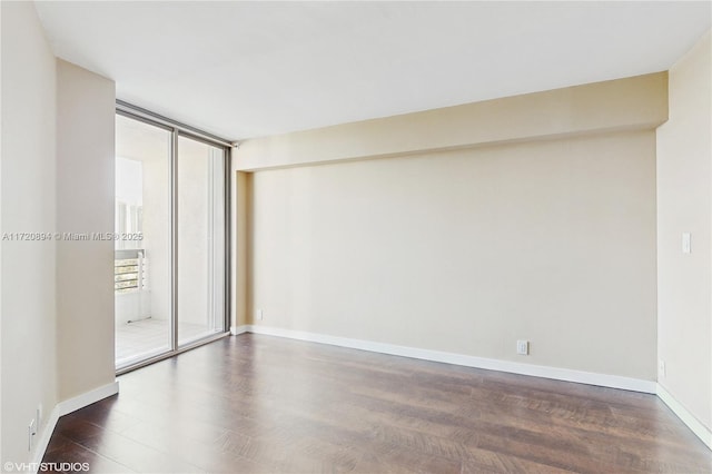 empty room with dark wood-type flooring, a wealth of natural light, and floor to ceiling windows