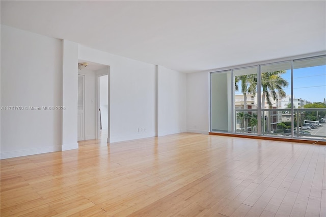9381 E Bay Harbor Dr Unit 301N, Bay Harbor Islands, FL 33154 - spare room with light wood-type flooring, floor to ceiling windows, and baseboards