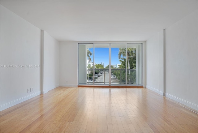 9381 E Bay Harbor Dr Unit 301N, Bay Harbor Islands, FL 33154 - empty room with expansive windows, light wood finished floors, and baseboards
