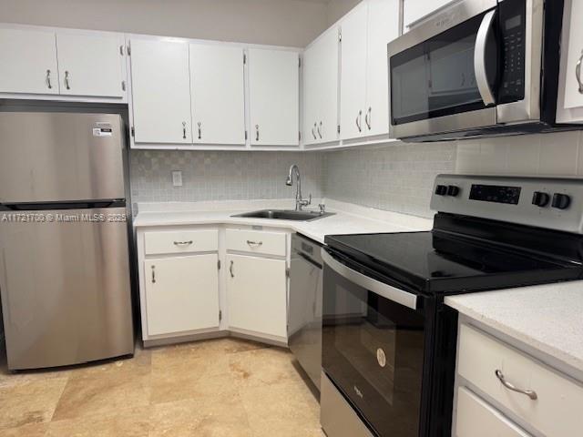 9381 E Bay Harbor Dr Unit 301N, Bay Harbor Islands, FL 33154 - kitchen featuring appliances with stainless steel finishes, a sink, light countertops, and decorative backsplash