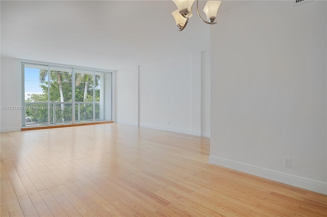 9381 E Bay Harbor Dr Unit 301N, Bay Harbor Islands, FL 33154 - unfurnished room featuring a chandelier, light wood-style floors, baseboards, and a wall of windows