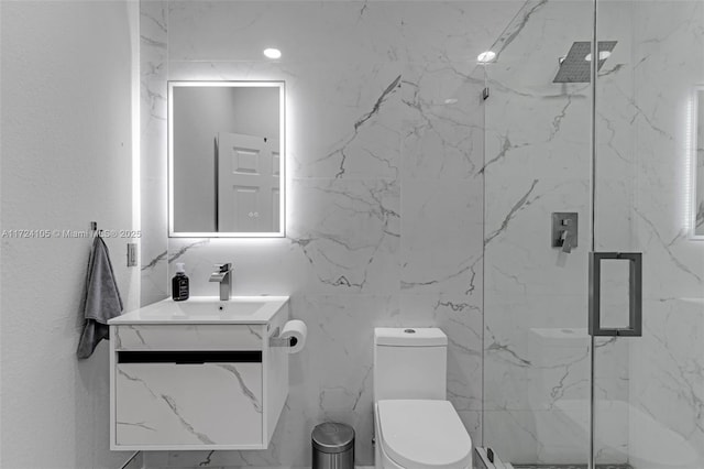 bathroom featuring a shower with door, vanity, and toilet