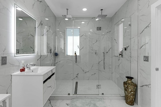 bathroom featuring a shower with door and vanity