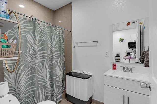 bathroom featuring toilet, walk in shower, and vanity