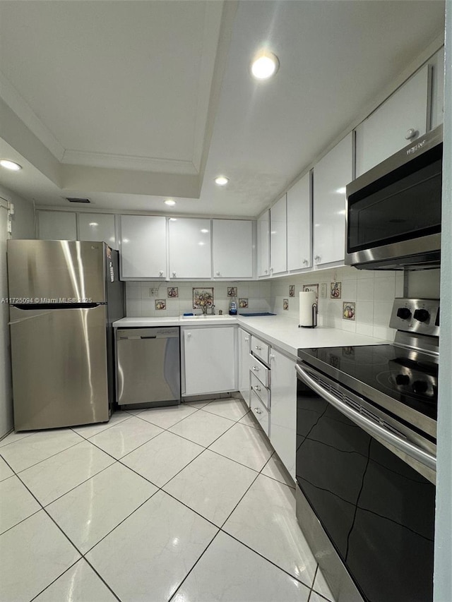 3180 S Ocean Dr Unit 721, Hallandale Beach, FL 33009 - kitchen with a raised ceiling, backsplash, white cabinets, and stainless steel appliances