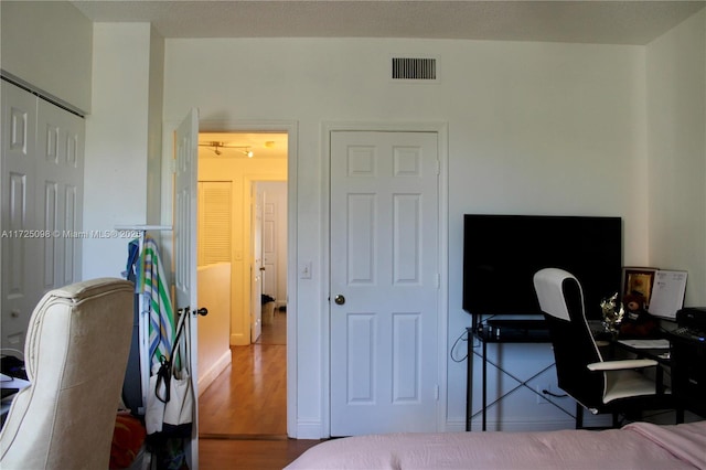 bedroom featuring wood finished floors, a closet, and visible vents
