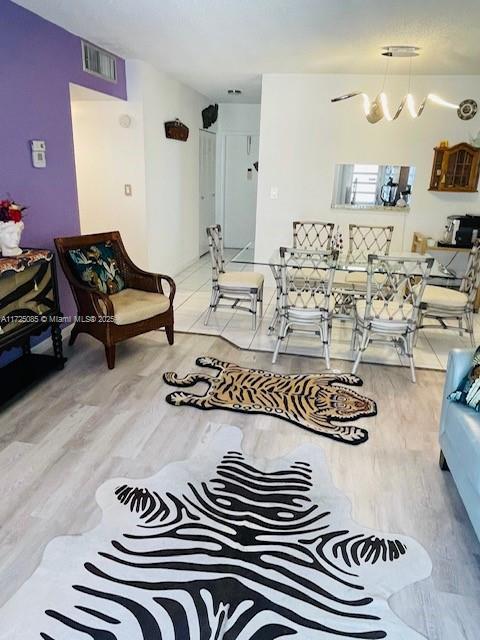 living room featuring a chandelier and light hardwood / wood-style flooring