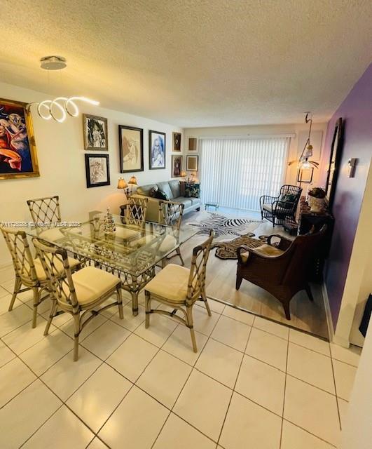 dining area with a textured ceiling and light tile patterned flooring