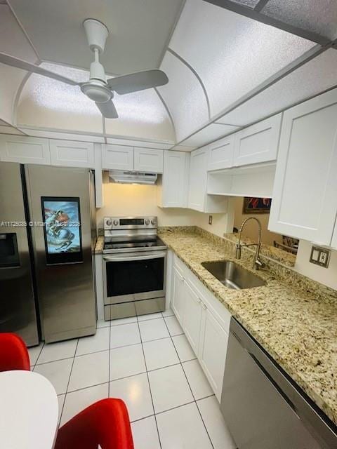 kitchen featuring appliances with stainless steel finishes, ceiling fan, sink, light tile patterned floors, and white cabinetry