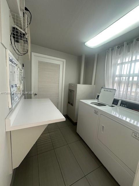 clothes washing area featuring washer and dryer and dark tile patterned flooring