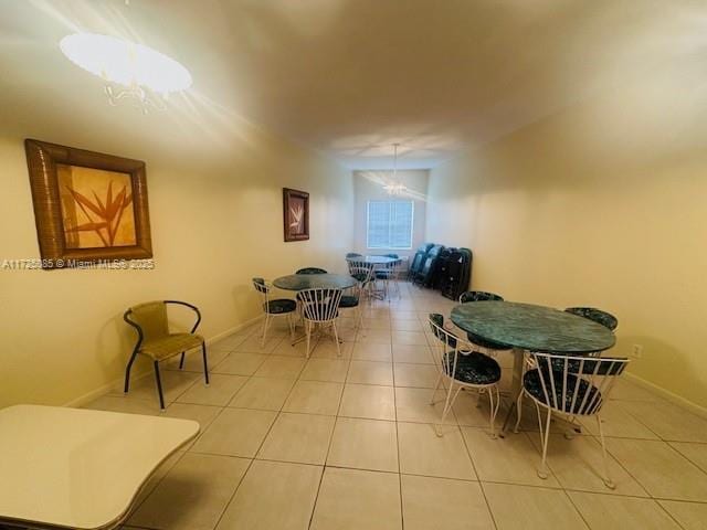 dining space with light tile patterned floors and a notable chandelier