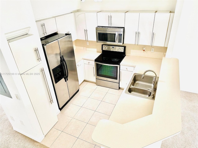 kitchen featuring white cabinets, light tile patterned floors, sink, and appliances with stainless steel finishes