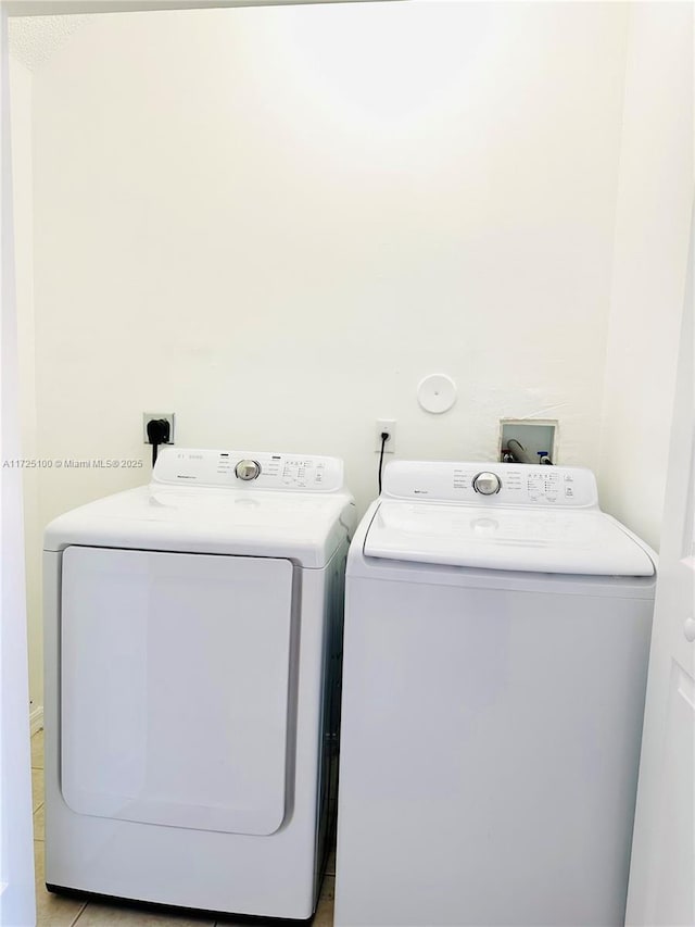 laundry room featuring light tile patterned floors and washing machine and clothes dryer