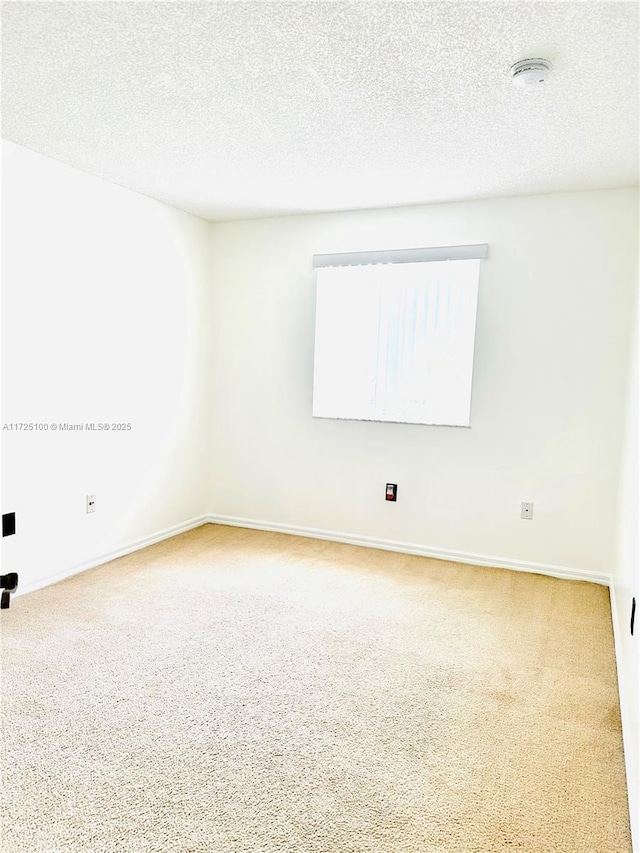 carpeted spare room featuring a textured ceiling