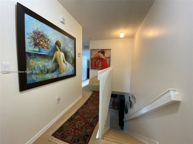 hallway with a textured ceiling