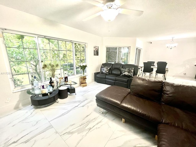 living room with a textured ceiling and ceiling fan with notable chandelier