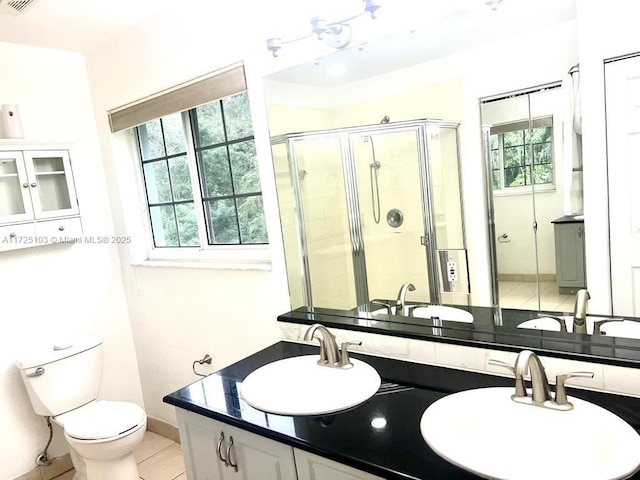 bathroom with tile patterned flooring, vanity, toilet, and walk in shower