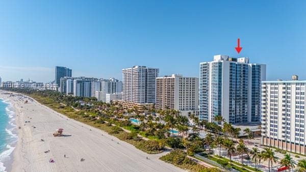 birds eye view of property featuring a water view and a beach view