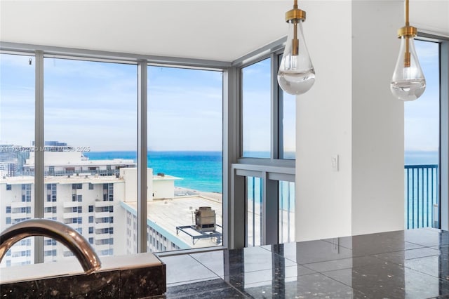 interior space featuring a healthy amount of sunlight, a beach view, and a water view