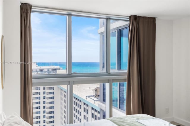 bedroom with multiple windows and a water view