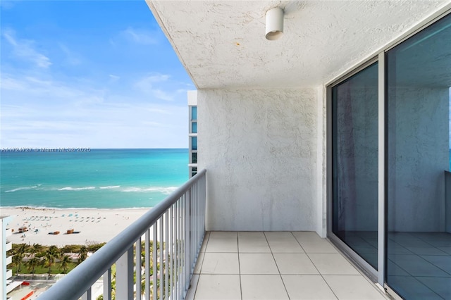 balcony with a water view and a beach view