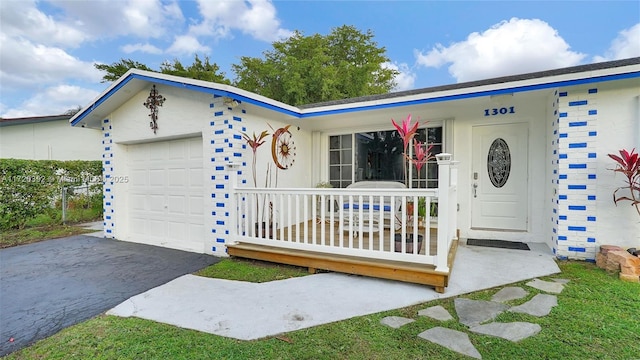 single story home featuring a porch and a garage