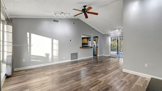 unfurnished living room featuring lofted ceiling, a textured ceiling, ceiling fan, and wood-type flooring