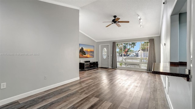 unfurnished living room featuring hardwood / wood-style flooring, a textured ceiling, lofted ceiling, crown molding, and ceiling fan