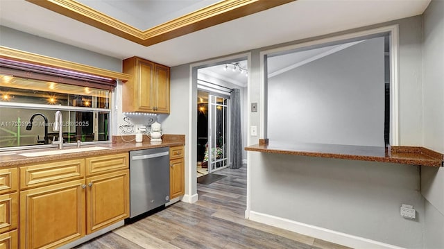 kitchen with sink, light hardwood / wood-style floors, ornamental molding, and stainless steel dishwasher