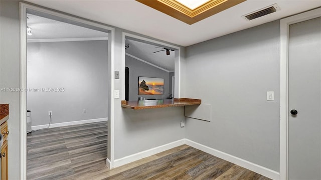 hall with a textured ceiling, hardwood / wood-style floors, vaulted ceiling, and crown molding