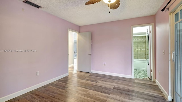 spare room featuring ceiling fan, light hardwood / wood-style floors, and a textured ceiling